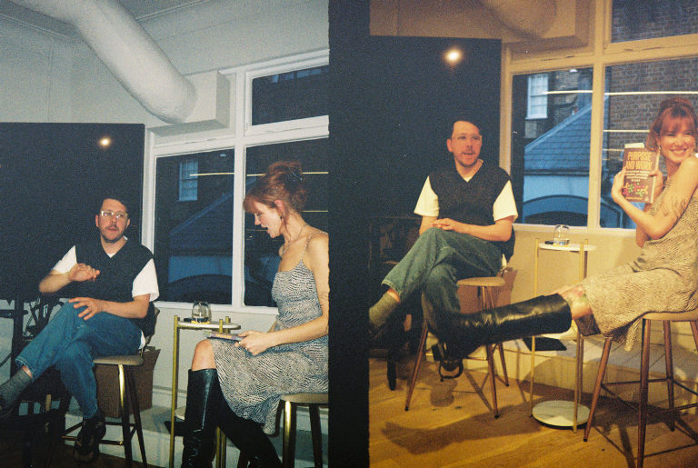 Two people talking on stools in a studio, shot on 35mm film